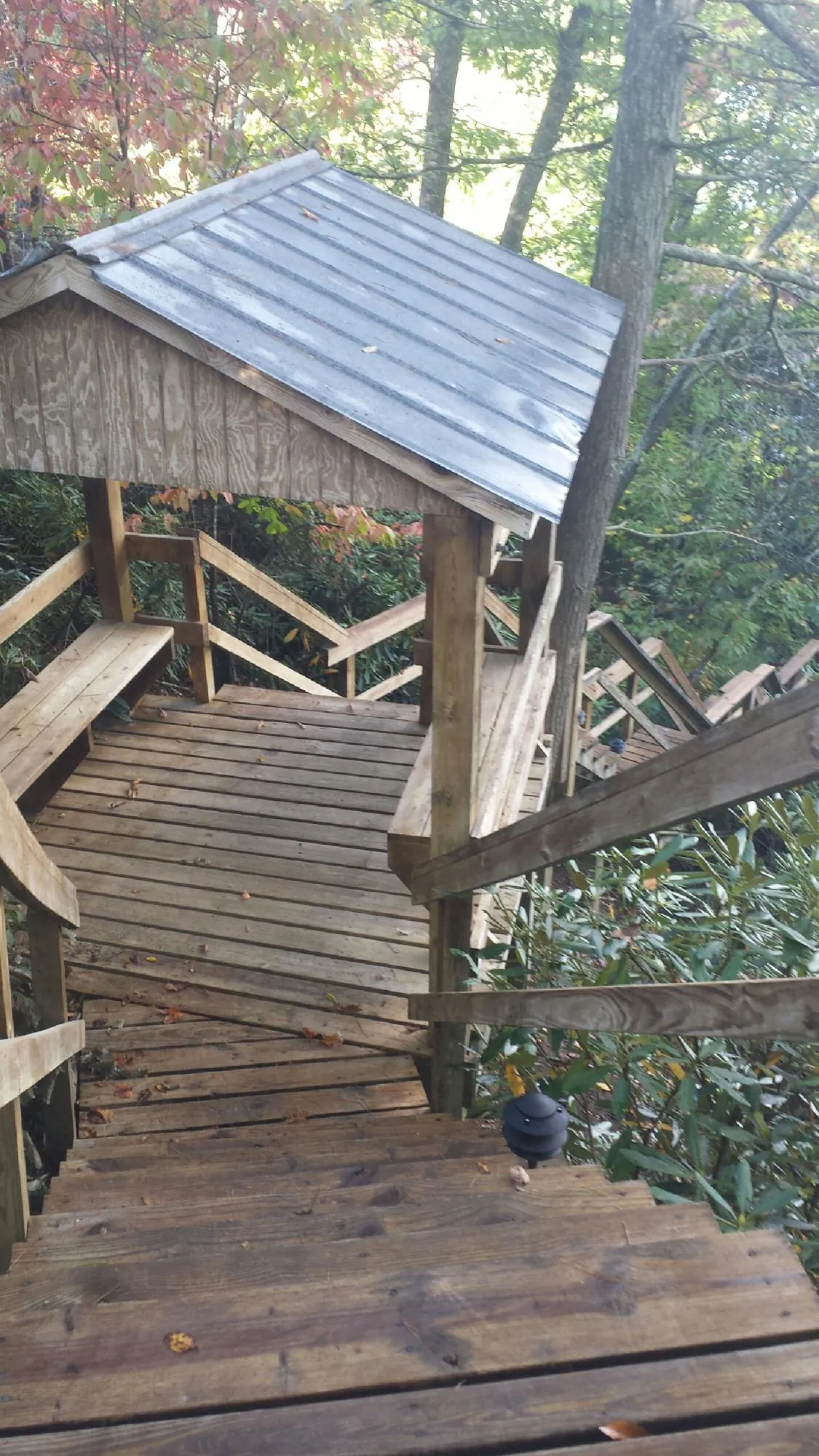 Metal roofed shelter over wooden steps on a wooded walkway — Skylight Repair & Installation work by our crew in Montague